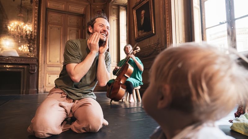 Destiné aux bébés de 6 à 36 mois, le spectacle « 3 petits moments » se compose de 3 séquences : découvrir, expérimenter, échanger. Les artistes, une violoncelliste et un danseur, jouent, observent et interagissent avec les bébés © Pierre Planchenault.