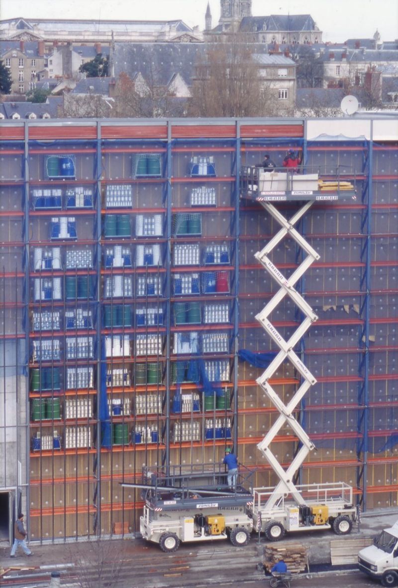 Rue de la Biscuiterie, fin 1999 : le Grenier du siècle en cours d'aménagement sur la façade arrière du Lieu Unique. Un mur translucide a ensuite été apposé pour contenir fûts et boîtes © Stéphane Ménoret - Archives de Nantes.