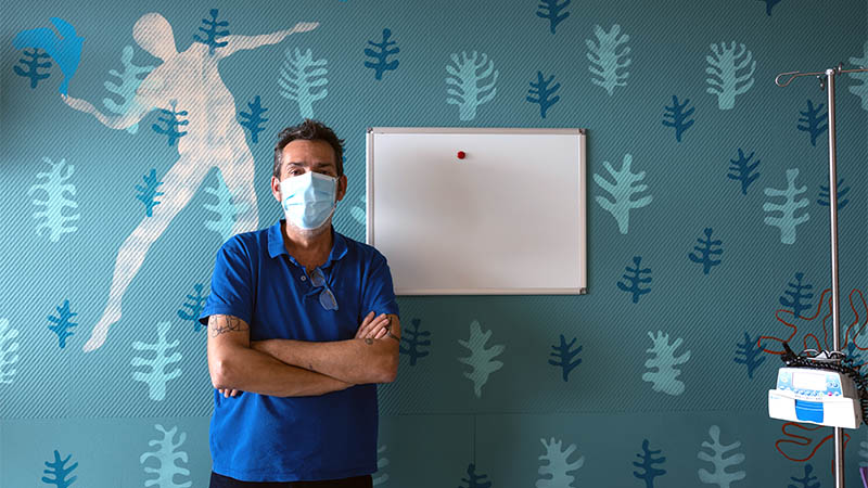 Frédéric Mazère devant la fresque qu’il a réalisée dans le service oncologie-dermatologie.
