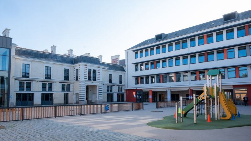 La nouvelle école Leloup-Bouhier est organisée en carré avec deux cours pour les maternelles et les primaires. Sur le bâtiment des années 1950 (à droite), les menuiseries en aluminium et le rouge rappellent l’ardoise et la brique du bâtiment fin XIXe siècle.