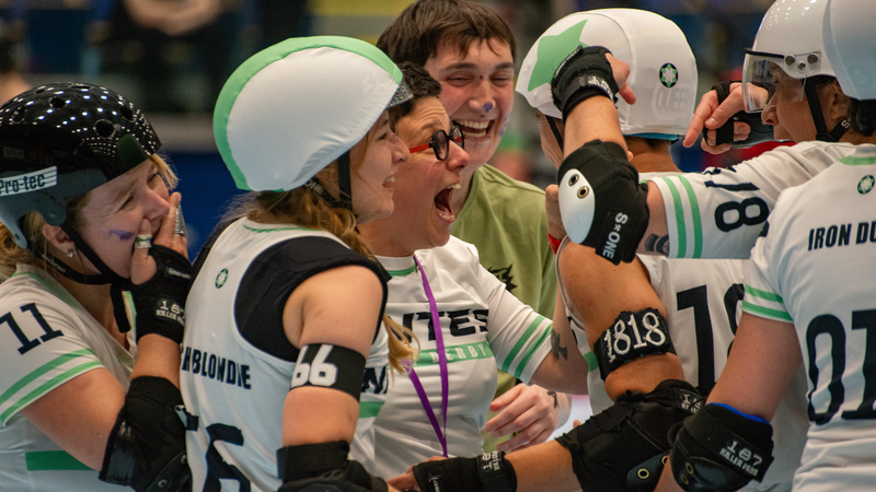 la photo représente présente 5 joueuses avec leurs casques et deux entraineuses se congratulant, sourires aux lèvres et larmes de joie après une victoire 