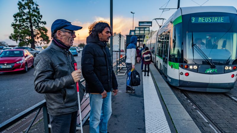 Personne malvoyante accompagnée par un copilote, sur le quai de la ligne 3 du tramway nantais