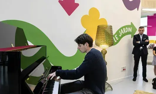 Un jeune est en train de jouer du piano.