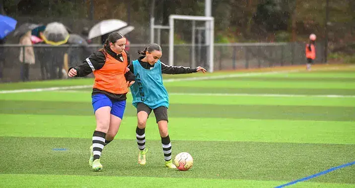 Sur la pelouse synthétique du terrain de la Marrière, à Nantes, deux jeunes footballeuses se disputent un  ballon lors d'un entraînement.