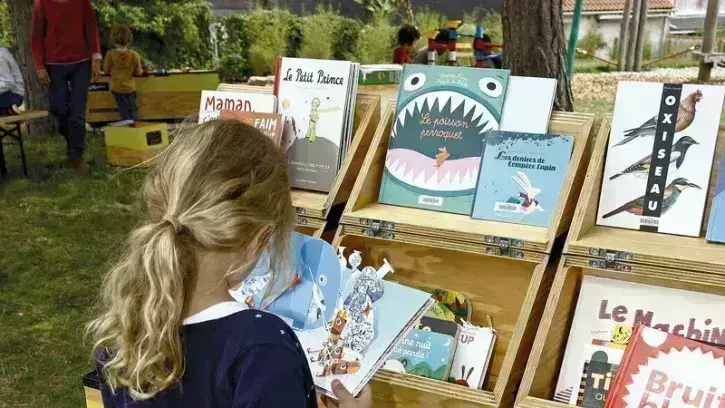 Une enfant en train de lire une bande-dessinée.