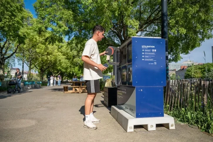 Un homme emprunte des raquettes de ping-pong dans un casier connecté.