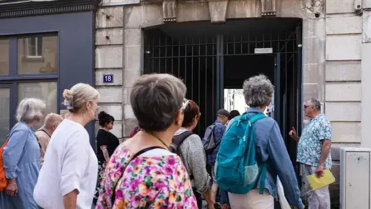 Roland Jubineau (à droite) guide les visiteurs à l'entrée du passage de la Poule-Noire, rue des Olivettes © Céline Jacq.