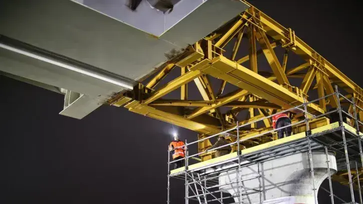 Les charpentiers ouvragistes au travail sur l'un des piliers du viaduc. Quatre nuits seront nécessaires pour que la charpente arrive sur la culée, dernier appui de l'ouvrage d'art.