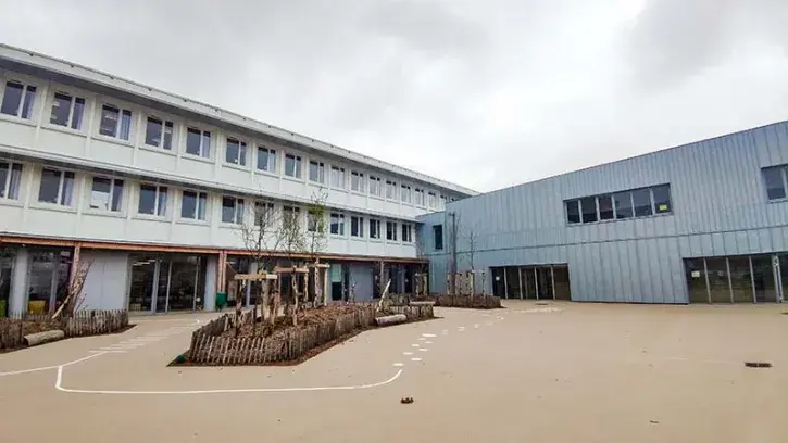Un nouveau bâtiment (ici à droite), en bois et zinc, a été construit à la place de l'ancienne restauration. Il vient connecter l'école élémentaire (à gauche) et l'école maternelle.  © Garance Wester